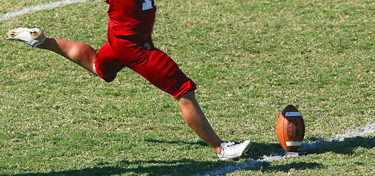 rödklädda ben måttar in en mäktig spark mot en boll