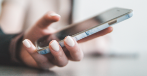 Kvinna håller en mobiltelefon