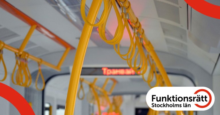 Fotografi av inredningen från en spårvagn. Det finns gulmarkerade ledstänger och handtag samt en display som visar ett stationsnamn.