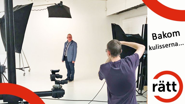 Krister iklädd blå kavaj och skjorta blir fotograferad i en ljus studio med många lampor. Fotografens rygg syns i bild.