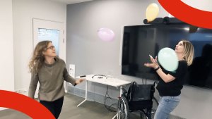 Två personer kämpar med att putta runt flera olika ballonger och samtidigt fotografera dem.