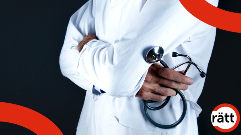 En person iklädd en vit läkarrock står med armarna i kors. Den ena handen håller i ett stetoskop.