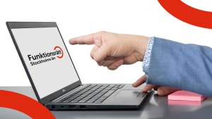 En hand pekar på en datorskärm som visar Funktionsrätt Stockholms läns logga