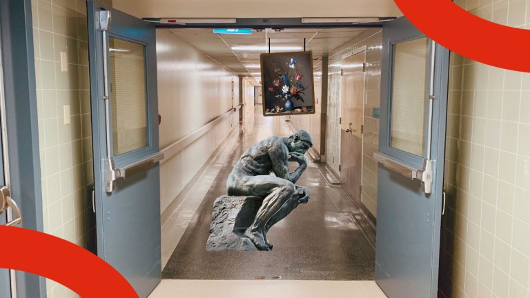 En staty står mitt i en sjukhuskorridor, och en tavla hänger från taket på låg höjd.