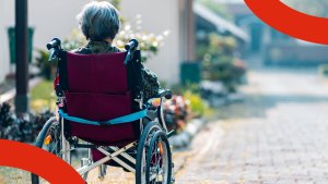 En kvinna sitter i en rullstol på ett somrigt torg