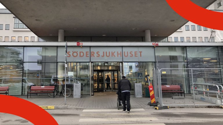 Entrén till Södersjukhuset. En person skjuter fram en person i rullstol mot ingången.