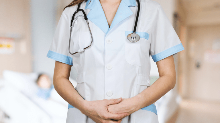 En person i vita sjukhuskläder och ett stetoskop om halsen.