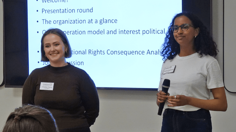 Josefine och Salina står framför en presentationsskärm och håller i mötet.