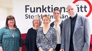 Presidiet och c-politiker står framför Funktionsrätt Stockholms läns logga