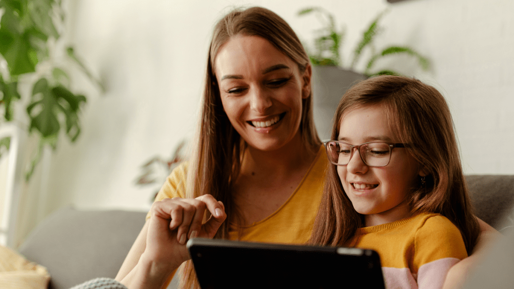 En kvinna och ett barn använder en surfplatta. Båda ler glatt. Bilden är samma som på rapporten om digitalt utanförskap.