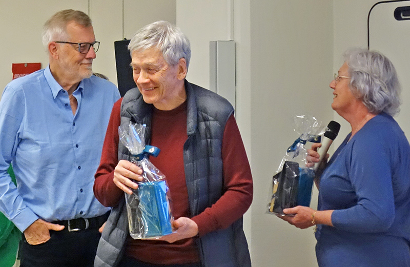 Åse räcker fram en present till Jan. Björn håller sin present och ser glad ut.