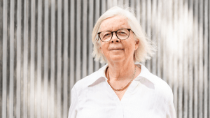 Annika Hässler i vit skjorta och vinden i håret ler mot kameran.