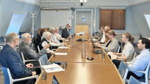 Samverkansgruppen sitter samlad kring ett långbord och diskuterar.