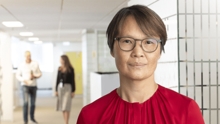 Locums vd Victoria Hörnedal ler in i kameran. Hon har kortklippt mörkt hår, glasögon och en röd tröja.