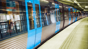 Ett tunnelbanetåg står inne vid en gul plattform.