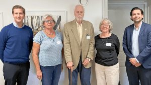 Fem personer står på rad. De ler in i kameran.