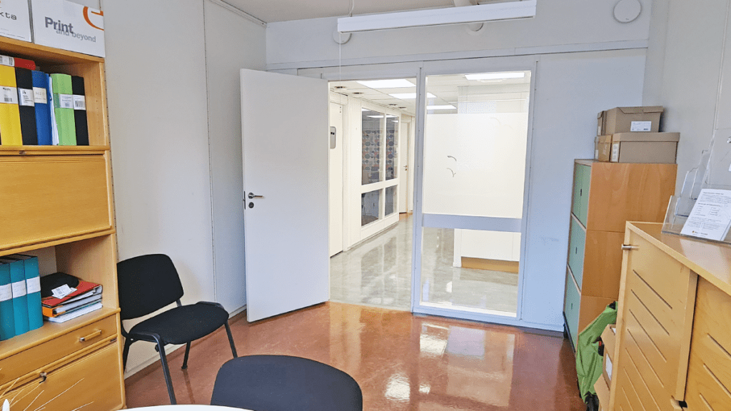 Kontorsrum vy mot dörren och korridoren utanför.