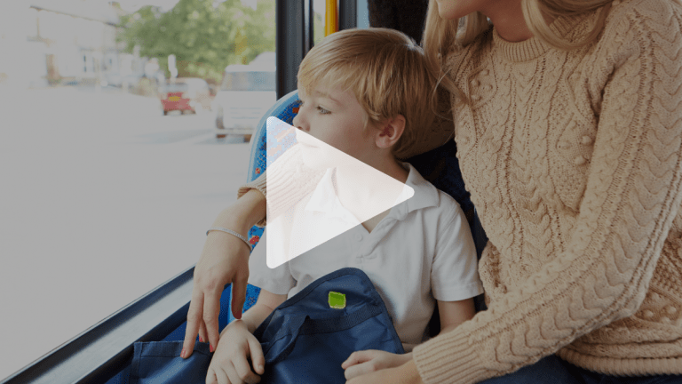 En spela-knapp ligger ovanpå en bild och ger en ledtråd om att det rör sig om en film. På bilden sitter en pojke med en ryggsäck i knät ombord på en buss och tittar ut genom fönstret. Hans mamma sitter på platsen bredvid honom och håller ena armen om hans axlar.