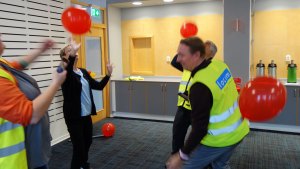 En grupp gör ballongövningen. Flera bär neongula västar.