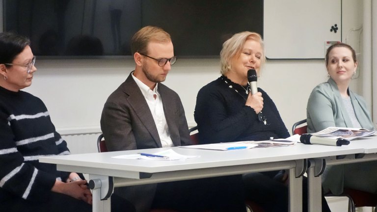 Närbild på Erica, Edvin, Therese och Johanna i panelen. Therese pratar i en handmikrofon. Våra nya rapporter ligger på bordet framför dem.