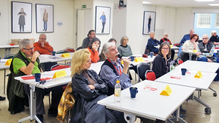 Vår ordförandestämma den 9 mars 2026. Flera personer i ett konferensrum. En av dem, en man med vitt hår och vit mustasch, talar i en handmikrofon.