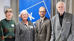 Fyra personer står på rad och ler mot kameran.
