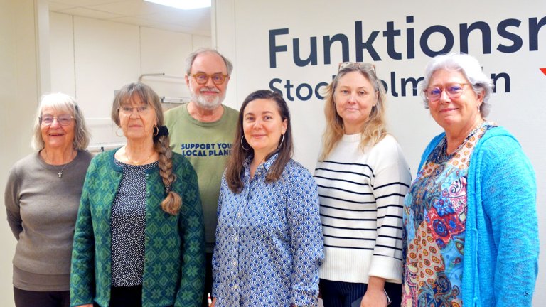Vårt presidium och fyra representanter från MP står framför en vägg, där Funktionsrätt Stockholms läns logga skymtar.